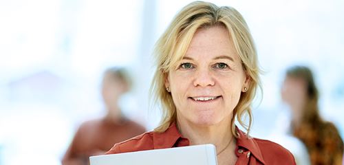 Kvinna med dator i famnen.