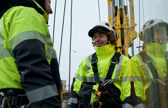 Två personer i varselkläder och med säkerhetsselar.