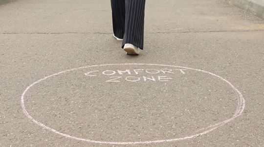 En person har klivit ur en ring på marken där det står "comfort zone".